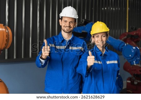 Engineer team, Automatic robotics arms in storage warehouse. Portrait of engineer wear safety uniform standing together in warehouse of robotics arms