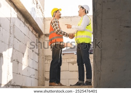 Engineer team building, teamwork contractor asian young man partnership, builder agreement handshake plan home project contract at construction site .Happy architect, surveyor worker shaking hands.