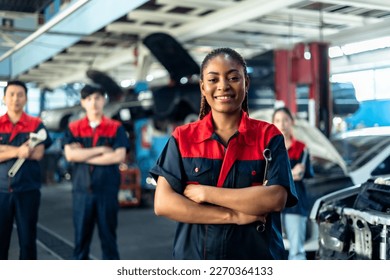 Engineer team checking under car condition on lifter in garage.Young auto mechanic in uniform is looking at camera and smiling examining car. - Powered by Shutterstock