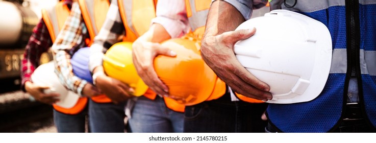 Engineer team holding hardhat standing in row ready for work Worker diversity group wearing vest ppe for safety in site train garage Expert construction project manager leadership banner cover design 