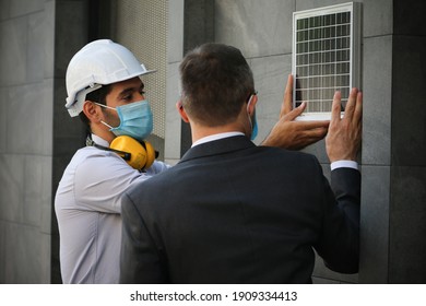 Engineer Team Meeting And Discussion About Solar Roof Project Installation With Site Manager, They Wear Face Mask Covid-19 Protection