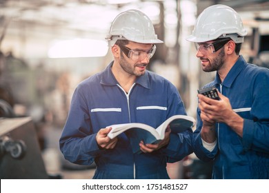 Engineer team talking together teach and learn engineering technical about using machine with open instruction manual text book in factory workplace.