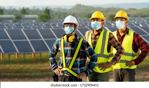 Engineer Team Wearing Masks To Protect The Virus. Covid 19 Works On Solar Photovoltaic, Solar Energy, Installs New Solar Panels At Industrial Plants.