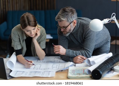 Engineer team working in office with blueprints and architect equipment, sketching, negotiating and planning construction project. Partners discussing at work. Business construction concept. - Powered by Shutterstock