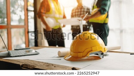 Engineer teams meeting working together wear worker helmets hardhat on construction site in modern city.Asian industry professional team in sun light
