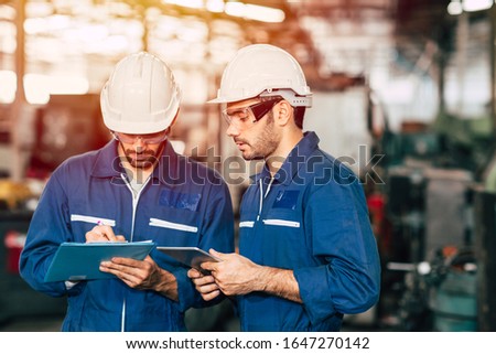 Engineer teamwork cooperate with worker to checking factory machine for safety and talking together.