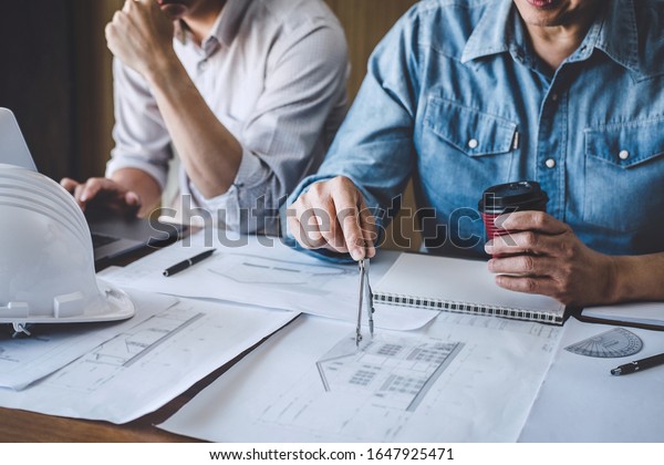 Engineer Teamwork Meeting, Drawing working on\
blueprint meeting for project working with partner on model\
building and engineering tools in working site, Construction and\
structure concept.
