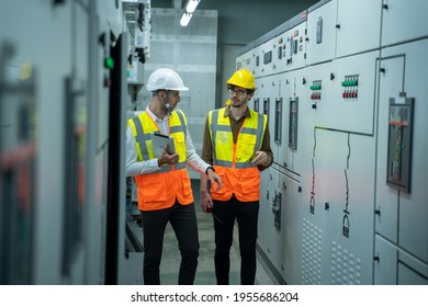 Engineer and technical worker working on the checking status switchgear electrical energy distribution substation at industry factory.