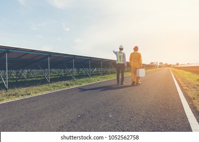engineer and technician checking efficiency of solar panel at solar power plant ; expertise service team working on measuring efficiency of operation and maintenance at solar plant 
