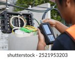 Engineer or technician checking fiber optic cables in internet splitter box.Fiber to the home equipment. FTTH internet fiber optics cables and cabinet.	