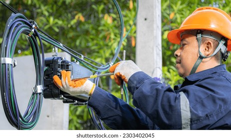 Engineer or technician checking fiber optic cables in internet splitter box.Fiber to the home equipment. FTTH internet fiber optics cables and cabinet.	