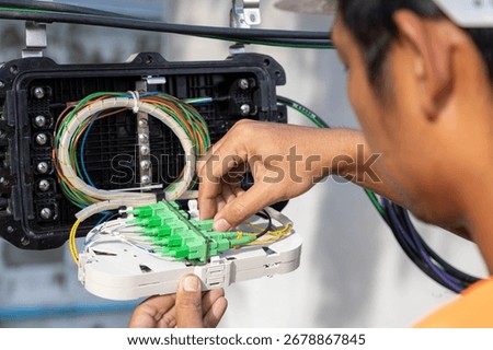 Engineer or technician checking fiber optic cables in internet splitter box.Fiber to the home equipment. FTTH internet fiber optics cables and cabinet.	