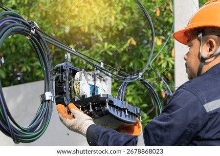 Engineer or technician checking fiber optic cables in internet splitter box.Fiber to the home equipment. FTTH internet fiber optics cables and cabinet.	