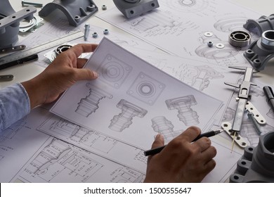 Engineer technician designing drawings mechanical parts engineering Enginemanufacturing factory Industry Industrial work project blueprints measuring bearings caliper tools - Shutterstock ID 1500555647
