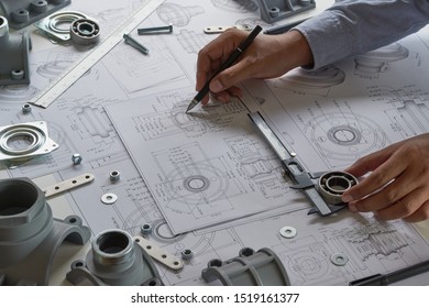 Engineer technician designing drawings mechanical parts engineering Enginemanufacturing factory Industry Industrial work project blueprints measuring bearings caliper tools - Shutterstock ID 1519161377