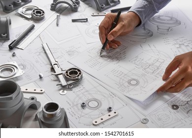 Engineer technician designing drawings mechanical parts engineering Engine
manufacturing factory Industry Industrial work project blueprints measuring bearings caliper tools  - Shutterstock ID 1542701615