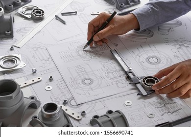 Engineer technician designing drawings mechanical parts engineering Engine
manufacturing factory Industry Industrial work project blueprints measuring bearings caliper tools - Shutterstock ID 1556690741