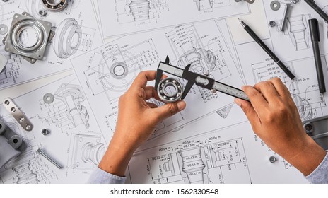 Engineer Technician Designing Drawings Mechanical parts Engineering Engine
Manufacturing Factory Industry Industrial Work Project Blueprints Measuring Bearings Caliper Tools