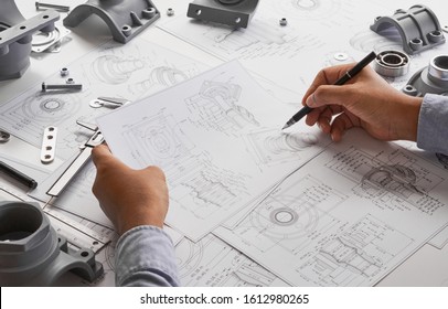 Engineer technician designing drawings mechanical parts engineering Engine
manufacturing factory Industry Industrial work project blueprints measuring bearings caliper tools - Shutterstock ID 1612980265