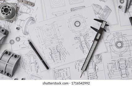 Engineer technician designing drawings mechanical parts engineering Engine
manufacturing factory Industry Industrial work project blueprints measuring bearings caliper tool. - Shutterstock ID 1716542992