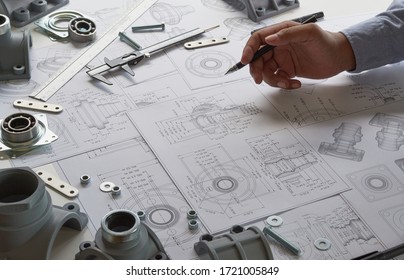 Engineer technician designing drawings mechanical parts engineering Engine
				manufacturing factory Industry Industrial work project blueprints measuring bearings caliper tools