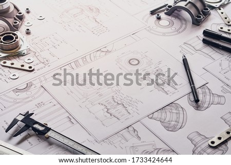 Engineer technician designing drawings mechanical parts engineering Engine
manufacturing factory Industry Industrial work project blueprints measuring bearings caliper tools