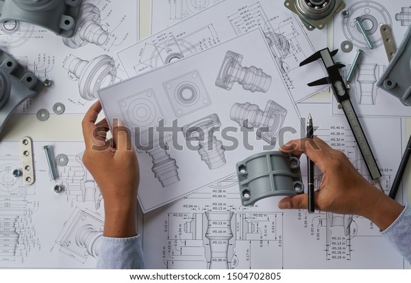 Engineer\
technician designing drawings mechanical parts engineering\
Engine\
manufacturing factory Industry Industrial work project\
blueprints measuring bearings caliper\
tools