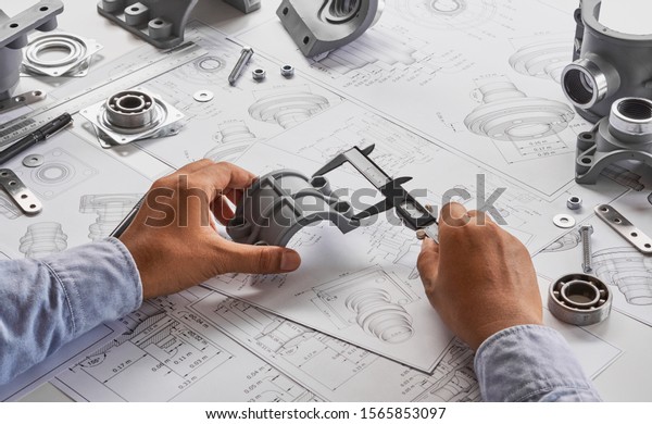 Engineer\
technician designing drawings mechanical parts engineering\
Engine\
manufacturing factory Industry Industrial work project\
blueprints measuring bearings caliper\
tools