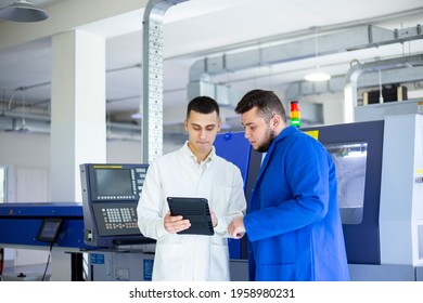 Engineer and technician discussing production process at factory