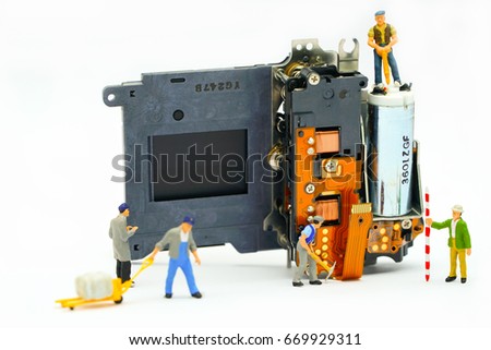 Engineer and technician Minitures are fixing camera shutter assembly , Miniture workers  are checking  optics and carry out maintenance and cleaning of the broken camera at the service center.