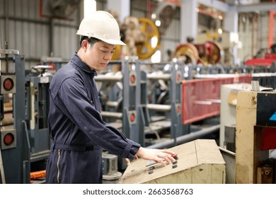 Engineer or technician operating control and pushing button machine in the factory