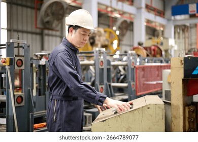 Engineer or technician operating control and pushing button machine in the factory