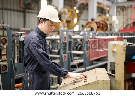 Engineer or technician operating control and pushing button machine in the factory