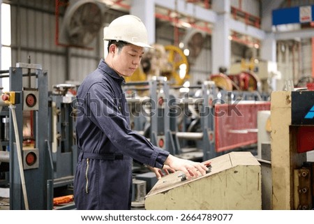 Engineer or technician operating control and pushing button machine in the factory