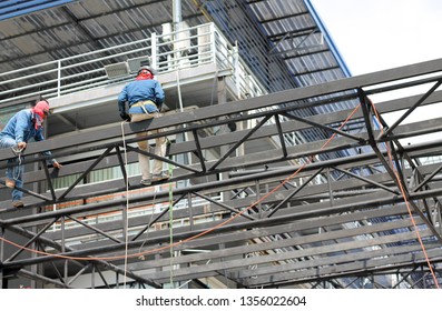 Engineer technician watching team of workers on high steel platform,Engineer technician Looking Up and Analyzing an Unfinished Construction Project. - Shutterstock ID 1356022604