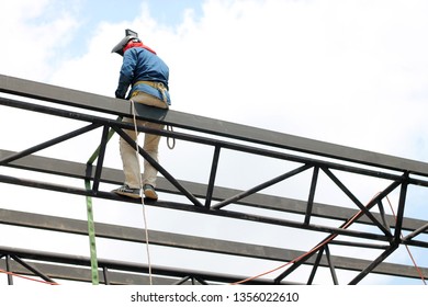 Engineer technician watching team of workers on high steel platform,Engineer technician Looking Up and Analyzing an Unfinished Construction Project. - Shutterstock ID 1356022610