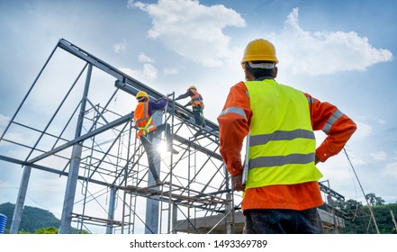 Engineer technician watching team of workers on high steel platform,Engineer technician Looking Up and Analyzing an Unfinished Construction Project. - Shutterstock ID 1493369789