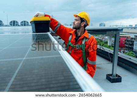 Engineer or technician worker put toolbox on solarcell panel during check or maintenance on rooftop of factory building.