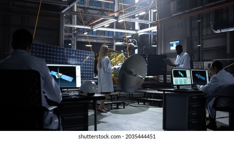 Engineer And Technician Working On Satellite Construction. Aerospace Agency: Diverse Team Of Scientists Using Technological Equipment And Laptop Computer To Develop Spacecraft For Space Exploration.