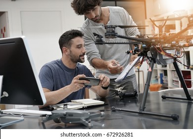 Engineer and technician working together on drone in office - Powered by Shutterstock