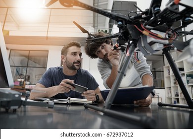 Engineer and technician working together on drone in office - Shutterstock ID 672937012