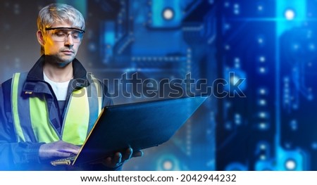 Engineer at technological enterprise. Production worker with laptop. Modern production worker concept. Male engineer in yellow vest. Technological Engineer Career. Blurred PCB in background.