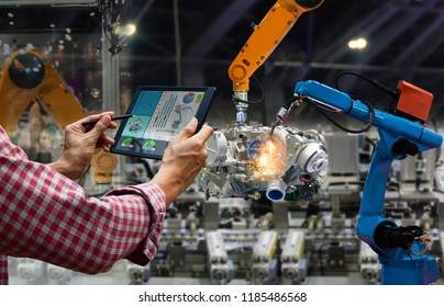 Engineer touch screen control robot the production of factory parts engine manufacturing industry robots and mechanical arm - Shutterstock ID 1185486568
