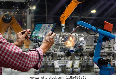 Engineer touch screen control robot the production of factory parts engine manufacturing industry robots and mechanical arm