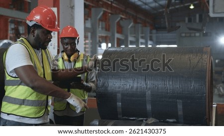 Engineer two worker man African black marking inspection on roll metal sheet before shipment in warehouse of Metal Sheet factory, Physical inventory count, checking stock industry