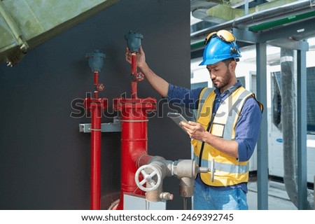Engineer under checking the industry chilled water fan coil unit air conditioner is water cooling tower air chiller HVAC system of large industrial building to control air system