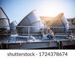 Engineer under checking the industry cooling tower air conditioner is water cooling tower air chiller HVAC of large industrial building to control air system.