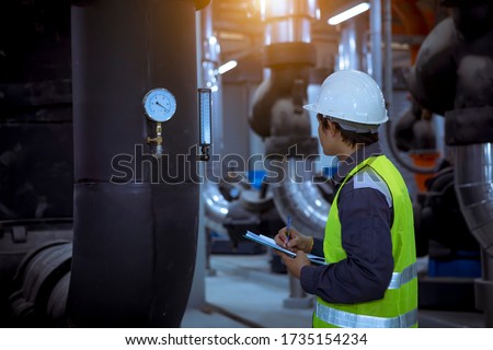 Engineer under checking the industry cooling tower air conditioner is water cooling tower air chiller HVAC of large industrial building to control air system.