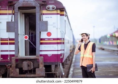 Engineer under inspection and checking construction process railway switch and checking work on railroad station tablet. Engineer wearing safety uniform and safety helmet in work. Checking concept