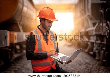 Engineer under inspection and checking construction process railway switch and checking work on railroad station by notebook .Engineer wearing safety uniform and safety helmet in work.